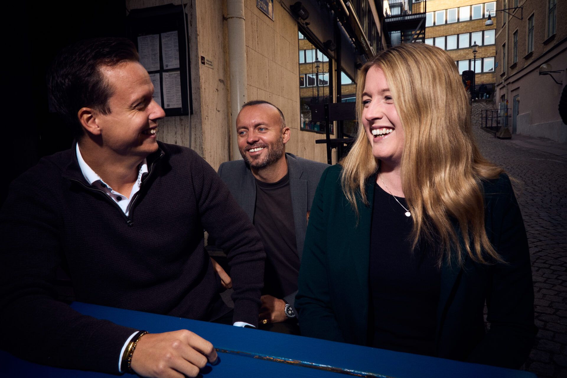 Tre glada medarbetare från Oddwork i utomhusmiljö